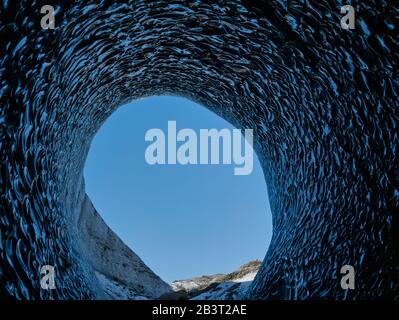 Der Blick von der blauen Gletscherhöhle auf den blauen Himmel Stockfoto