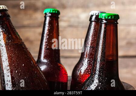 Kalte Flaschen Bier im Eimer auf dem Holzhintergrund Stockfoto