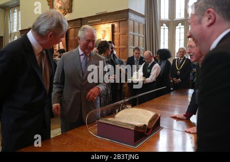 Dem Prince of Wales (rechts) wird das Rote Buch von Hergest bei einem Besuch des Jesus College in Oxford in Anerkennung der Wiedereinsetzung des Jesus Chair of Celtic, einer Professur für Celtic Studies an der Universität Oxford, gezeigt. Stockfoto