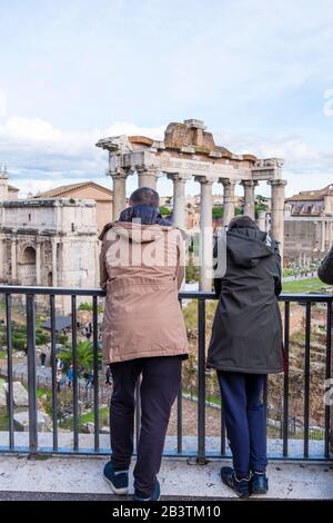 Die Menschen auf dem Kapitolinischen Hügel blicken über das Forum Romanum in Richtung Kolosseum, Rom, Italien Stockfoto