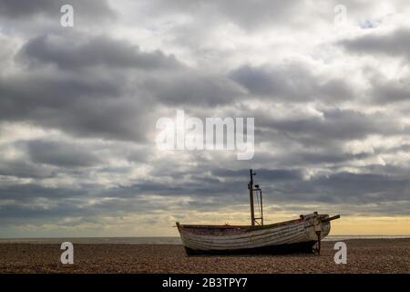 Altes verlassene Fischerboot mit dramatischem Himmel auf Aldeburgh Beach, Aldeburgh, Suffolk. GROSSBRITANNIEN Stockfoto
