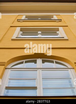 Weißes Kunststofffenster an der gelben Fassade Stockfoto