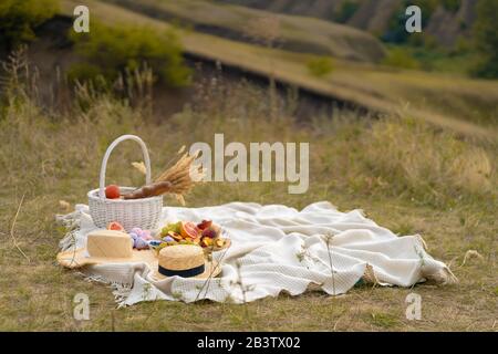 Stilvolle Sommer Picknick auf einer weißen Decke. In einem malerischen Ort der Natur der Hügel Stockfoto