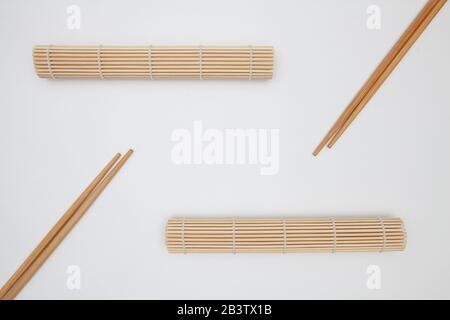 Bambusmatte mit Essstäbchen für Sushi auf dem weißen Tisch. Lebensmitteldesign Stockfoto