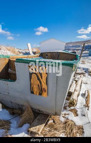 Geschnitzte Kunst auf einem alten Fischerboot im Winter in dem historischen Dorf Ferryland, Neufundland, Kanada [keine Eigentumsfreigabe; Lizenzierung für Editorial u. Stockfoto