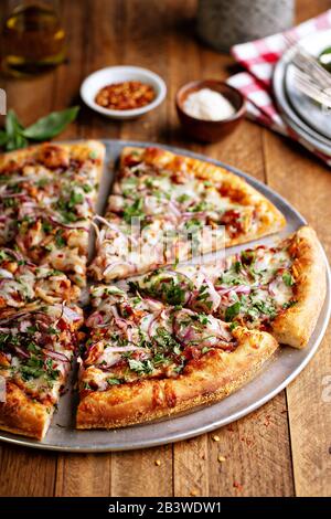 Grillpizzen mit heißer Soße und roter Zwiebel in Scheiben geschnitten Stockfoto