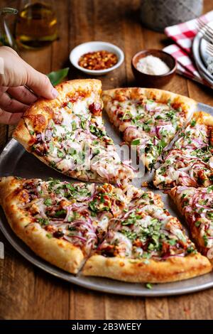 Grillpizzen mit heißer Soße und roter Zwiebel in Scheiben geschnitten Stockfoto
