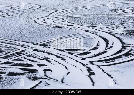 Fahrzeugbahnen in schneebedecktem Sand direkt abseits der Straße zum Cape Race Lighthouse, Neufundland, Kanada Stockfoto