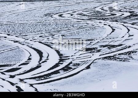 Fahrzeugbahnen in schneebedecktem Sand direkt abseits der Straße zum Cape Race Lighthouse, Neufundland, Kanada Stockfoto