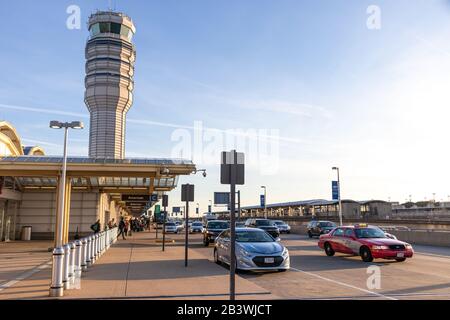 Ronald Reagan Washington National Airport Terminal B/C am geschäftigen, sonnigen Nachmittag mit Air Traffic Control Tower im Hintergrund gesehen. Stockfoto