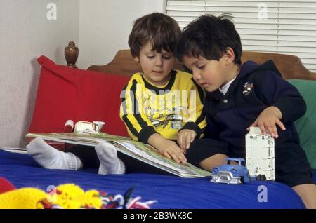 Austin Texas USA, 1996: Zweieinhalb Jahre alte Jungen, die sich gemeinsam das Bilderbuch angeschaut haben. HERR ©Bob Daemmrich Stockfoto