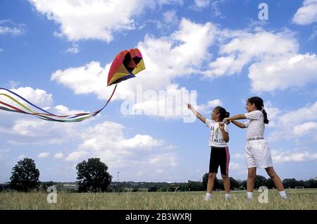 Austin Texas USA: Hispanische Mädchen fliegen einen Paraboldrachen in einem Stadtpark. ©Bob Daemmrich Stockfoto