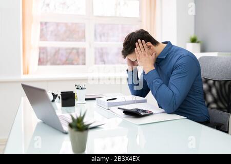 Junge Unternehmer, Die Die Steuer Am Schreibtisch Im Büro Berechnen Stockfoto
