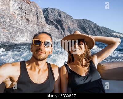 Selfie-Porträt eines Paares, das in der Nähe der felsigen Küste segelt. Bild auf Handy gemacht Stockfoto