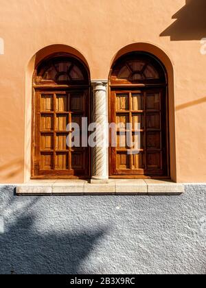 Architektonisches Fragment des alten hellen Gebäudes mit Bogenfenstern. Bild auf Handy gemacht Stockfoto