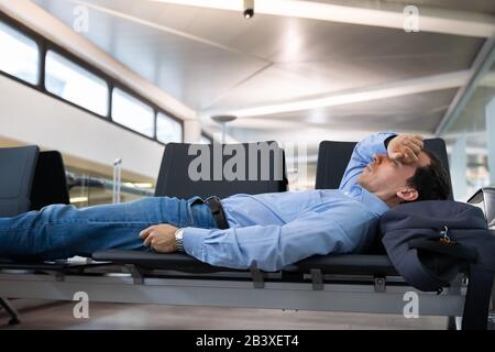 Verzögerter Flug. Mann Schläft Im Flughafenterminal Stockfoto