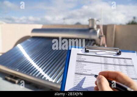 Klempner, Der Die Prüfung Des Solar-Energiekessels Durchgeführt Hat Stockfoto