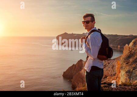 Tourist Wanderer zu Fuß am weißen Strand auf der Insel Santorini am ägeischen Meer, die Sommerlandschaft genießen. Mann unterwegs Stockfoto