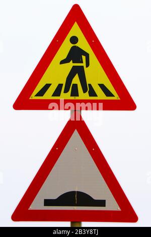 Fußgänger, die auf der Straße spazieren, mit einem Hinweisschild, einem gelben und einem roten Brett mit weißem Hintergrund Stockfoto