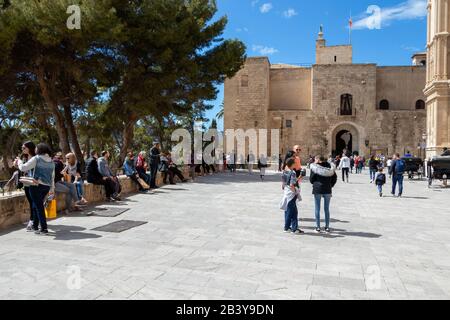 Palma, Mallorca - 10. April 2019: Touristen vor dem Königspalast von La Almudaina und der Catedral de Mallorca Stockfoto