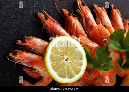 Rohe frische Garnelen Langostino Austral. Garnelen Meeresfrüchte mit Zitrone und Gewürzen auf dem Tisch Stockfoto