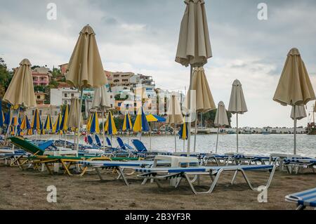 Bali, Crete, Griechenland - 10.09.2019: Schlechtes Wetter im Resort. Leerer Strand, Sonnenliegen und überdachte Sonnenschirme. Stockfoto