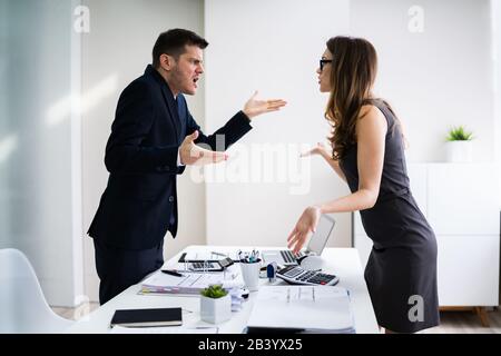 Seitenansicht Der Geschäftsleute, Die Sich Am Schreibtisch Im Büro Zerstritten Stockfoto