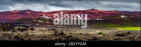 Panoramablick auf bunte und rauchige rhyolithe Vulkanberge in den isländischen Highlands in der Nähe des See Myvatn, Sommer, szenische dramatische Reiseroute Stockfoto