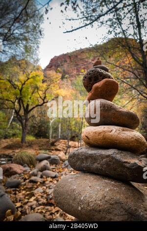 Gestapelte Kopfsteinpflaster in ruhiger und zzenähnlicher Natur mit Bergen und Bäumen in Sedona, Arizona in der Nähe des berühmten Felsvortexs der Kathedrale. Keine Menschen, Tageslicht. Stockfoto