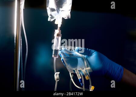 Die Krankenschwester bereitet den Beutel für sekundäre Infusionsmedikationslösung mit "Huckepack" für die Verabreichung mit primärer Infusionstüte und Infusionsschlauch vor. Stockfoto