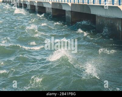 Grünliche Wasseroberfläche mit Stürmischen Wellen am Wassertor Stockfoto