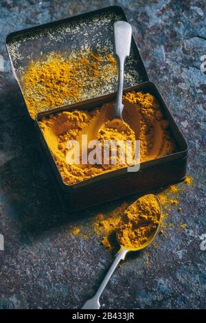 Kurkumulver. Aromatisches Gewürz in einer Zinn auf Schiefergrund Stockfoto