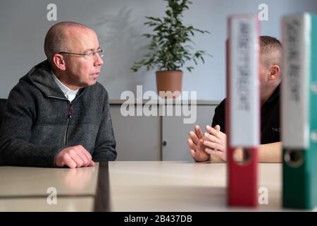 Lengerich, Deutschland. März 2020. Illustration - Sozialpastor Peter Kossen (l) vom Verein "Aktion Werden und Gerechtigkeit" (Aktion Würde und Gerechtigkeit) spricht mit einem Mann in einer Situation, der unter schwierigen Arbeitsbedingungen leidet. Kossen berät Arbeitsmigranten aus Ost- und Südosteuropa. Credit: Friso Gentsch / dpa / Alamy Live News Stockfoto