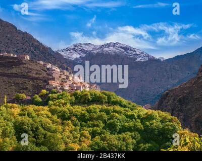 Das Berberdorf Aroumd im Hochatlas von Marokko mit dem schneebedeckten Jbel Toubkal, dem höchsten Berg Nordafrikas im hinteren Teil. Stockfoto