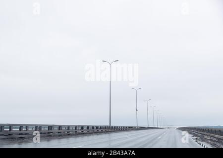 Industrie- und Verkehrskonzept der freien europäischen Autobahn zwischen Berge Landschaft Landschaft bei bewölktem und regnerischem Wetter.Regenstraße ohne Stockfoto