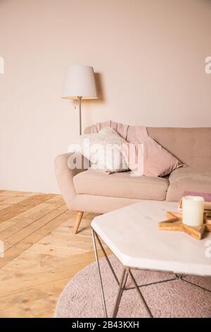 Zimmer im Loft-Stil.stilvolle, luxuriöse Innenausstattung mit Design-Tisch mit Kerze.Retro kleinen Tisch mit eleganten Accessoires und Sofa mit Kissen.Modern Stockfoto