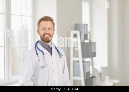 Kinderarzt steht in der weißen Klinik des Krankenhauses. Stockfoto