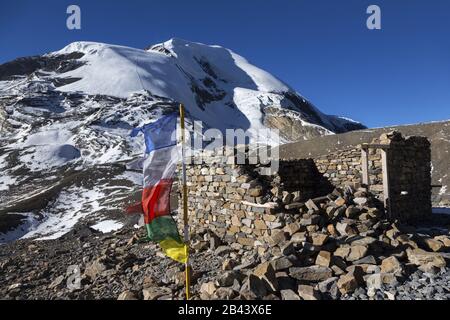 Ruinen der alten Steingebäude und vergletscherte Gipfellandschaft in der Nähe von Thorong oder Thorung La Pass auf dem Annapurna Circuit Hiking Trail in den Himalaya-Bergen Nepals Stockfoto