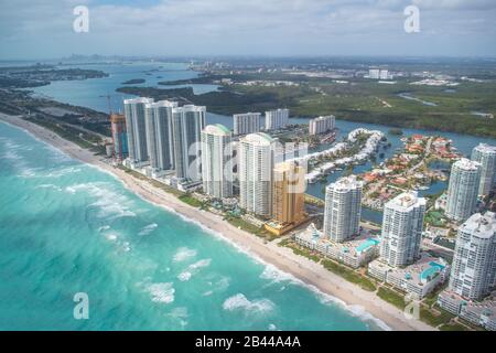 Gebäude am North Miami Beach, wie vom Hubschrauber aus gesehen, Florida. Wolkenkratzer entlang des Ozeans, Luftbild. Stockfoto