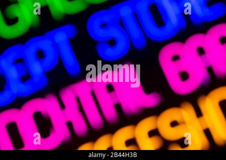 Neon-Hintergrund. Neon-Zeichen und Worte in verschiedenen Farben nachts auf der Straße. Elektrische Farbbeleuchtung für Mode- und Schönheitsdesign. Stockfoto