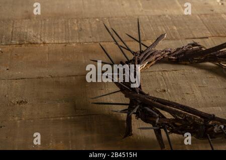 Dornenkrone auf Holzhintergrund mit Kopierraum. Österliches religiöses Motiv zur Erinnerung an die Auferstehung Jesu. Stockfoto