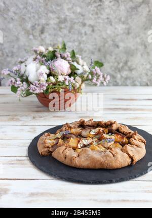 Galette mit Birnen und Käsebrie. Auch bretonische Galette genannt, Galette des Rois, Galeta. Französische Küche (Essen). Auf altem weißen Holzhintergrund. Stockfoto