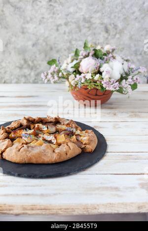 Galette mit Birnen und Käsebrie. Auch bretonische Galette genannt, Galette des Rois, Galeta. Französische Küche (Essen). Auf altem weißen Holzhintergrund. Stockfoto