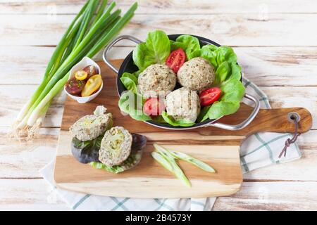 Diätetische Häckselchen, die im Ofen mit Brokkoli zubereitet werden und mit einer Rissohle serviert werden. Auf altem weißen Holzhintergrund. Stockfoto