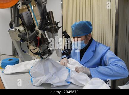 (200306) -- PEKING, 6. März 2020 (Xinhua) -- EIN Arbeiter trifft medizinische Schutzkleidung bei der Beijing Yingguan Dental Technology Co., Ltd. In Peking, Hauptstadt Chinas, 3. März 2020. (Xinhua/Ren Chao) Stockfoto