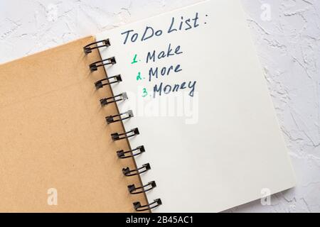 To-DO-Liste - verdienen Sie mehr Geld, wenn Sie Text auf dem Notizblock schreiben. Nahaufnahme. Stockfoto