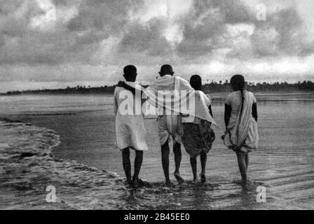 Mahatma gandhi mit Mitarbeitern, die am juhu-strand in mumbai in maharashtra, Indien, Asien, 1944 spazieren Stockfoto