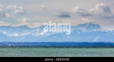 Panorama mit schneebedeckten alpen (Wettersteingebirge inkl. Zugspitze). Im Vordergrund der Starnberger See (Starnberger See). Dramatischer Himmel/Wolken Stockfoto