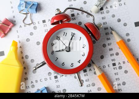 Testbogen, Wecker und Schreibwaren, Nahaufnahme Stockfoto