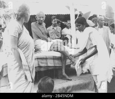 Mahatma Gandhi Füße werden von Enkelin Manu nach dem Ende des täglichen marsches in Noakhali West Bengalen Indien gewaschen Februar 1947 Alter Jahrgang 1900s Bild Stockfoto